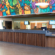 Long service counter with wood slat front beneath the lobby mural at Meadowvale Theatre
