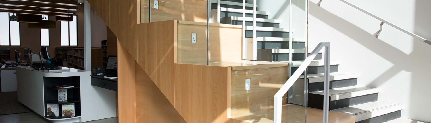 Wood-clad staircase with glass railing at St. Clair Silverthorn Library