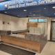 Wood-grain reception counter with stone-look ledge at Toronto Public Health Dental & Oral Health Services, Thorncliffe Park